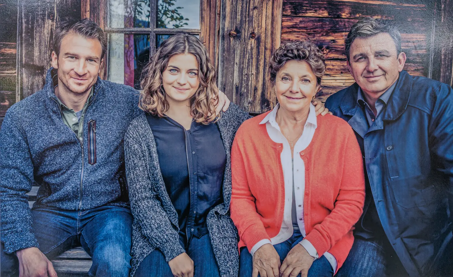 Familienporträt vor einer Tiroler Holzfassade am Bergdoktor-Drehort in Going