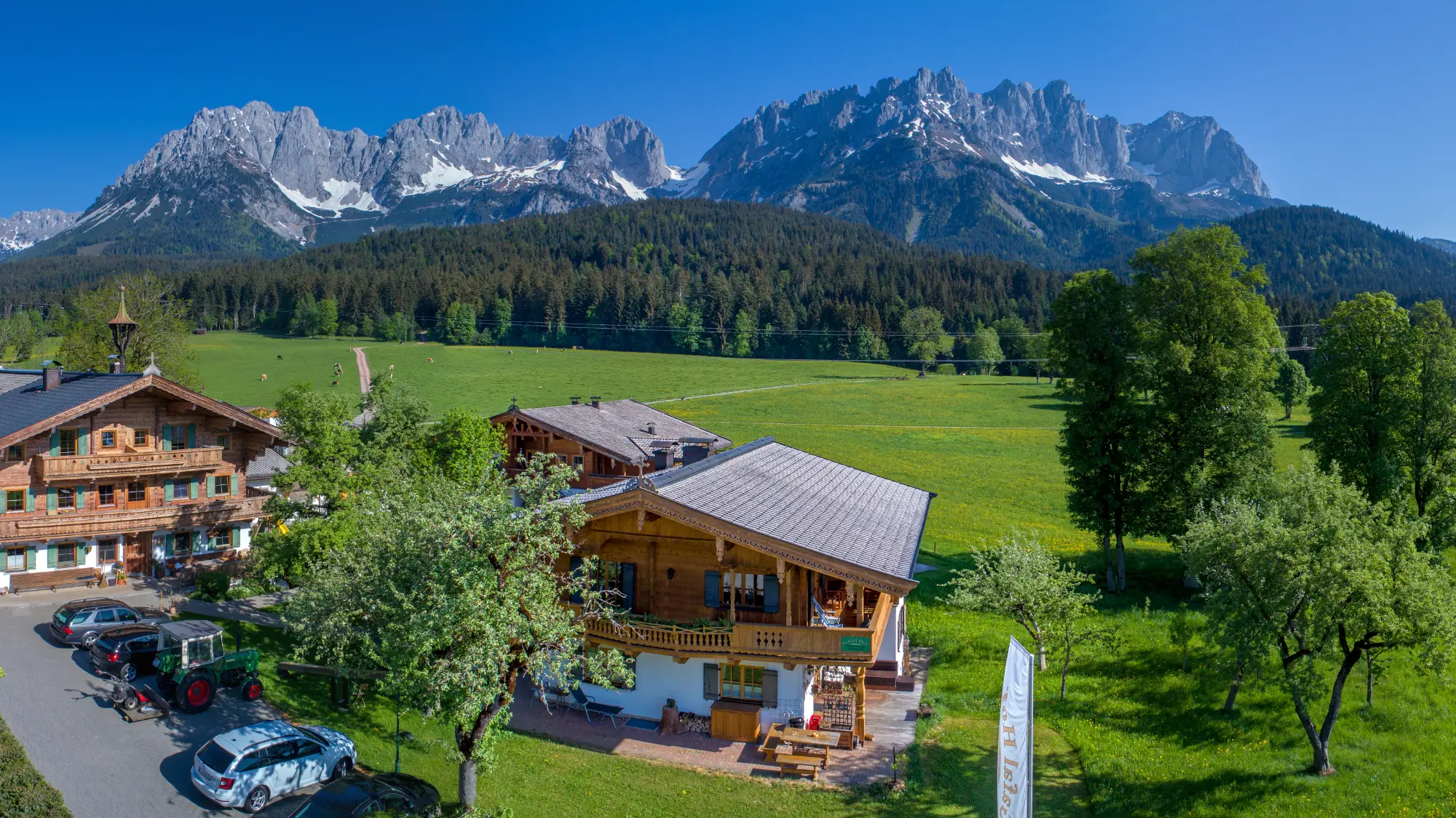 Der Gafalhof im Sommer aus der Luft, umgeben von Wiesen und dem Wilden Kaiser