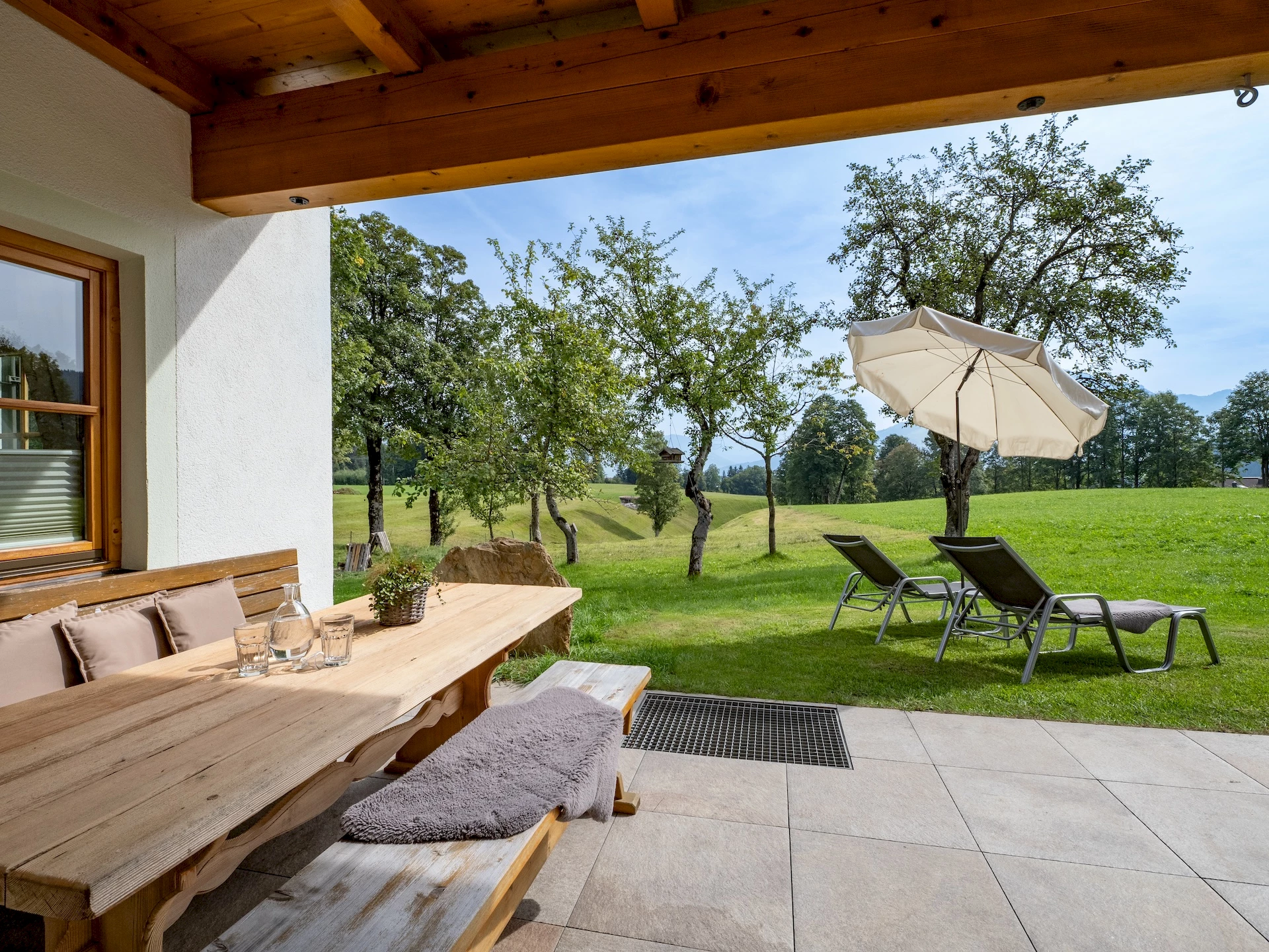Terrasse des Tirolerhauses mit Liegestühlen und Blick ins Grüne