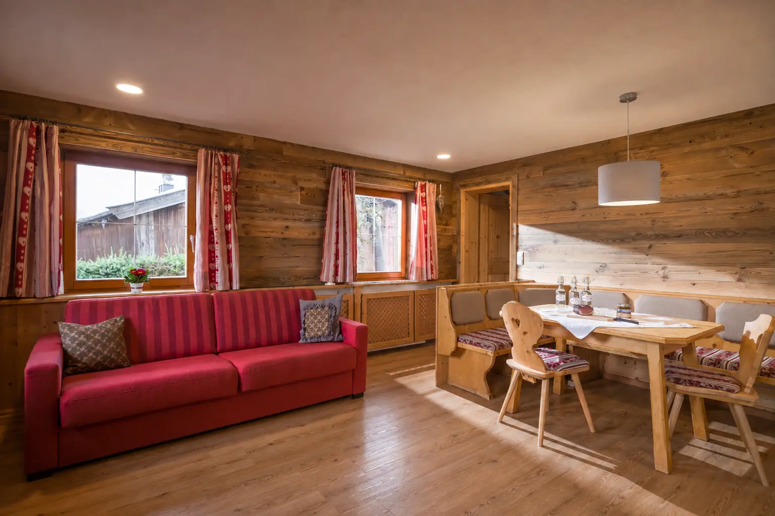 Living room with a red sofa in the Astbergblick apartment — Bauernhaus holiday flat, Going, Tyrol