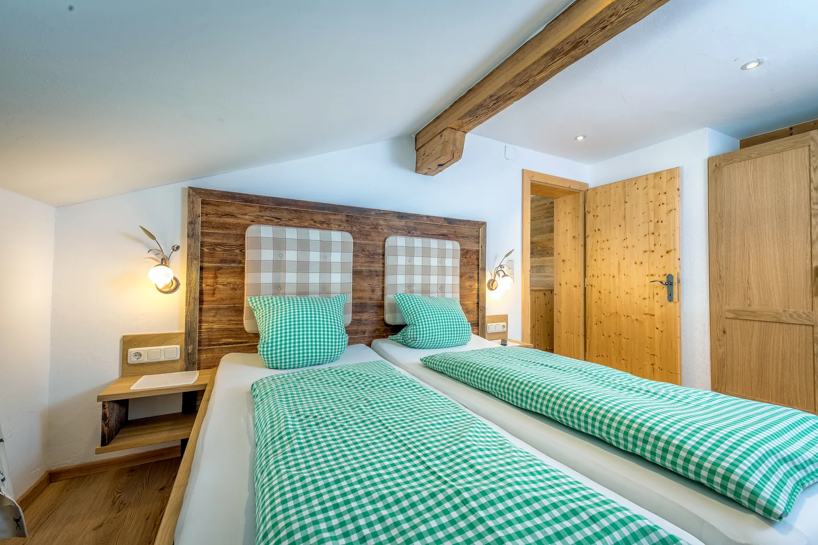 Schlafzimmer der Ferienwohnung Alpenblick mit gepolstertem Kopfteil und Kleiderschrank