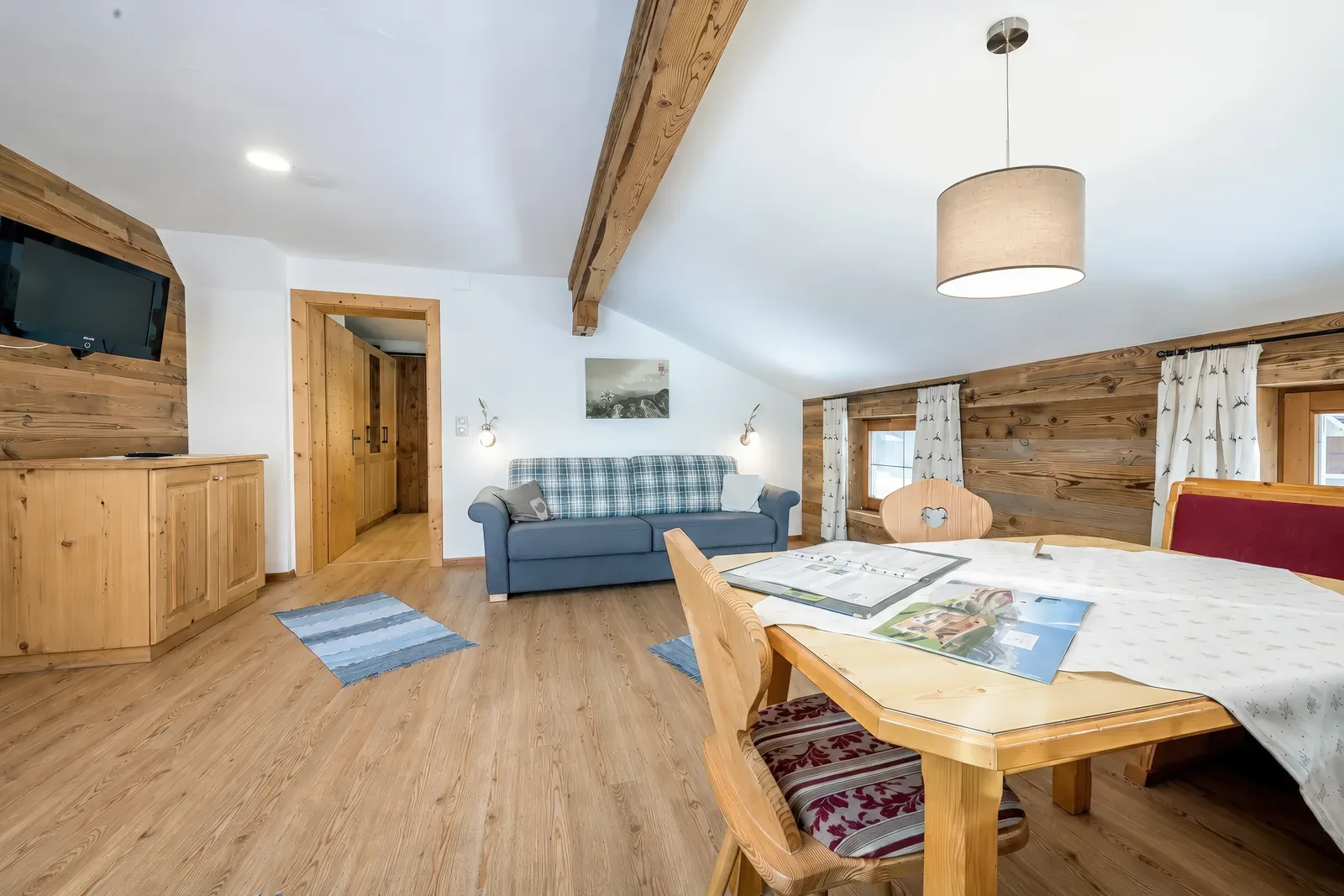 Wohn- und Essbereich im Alpenblick mit Schlafsofa, Fernseher und Esstisch