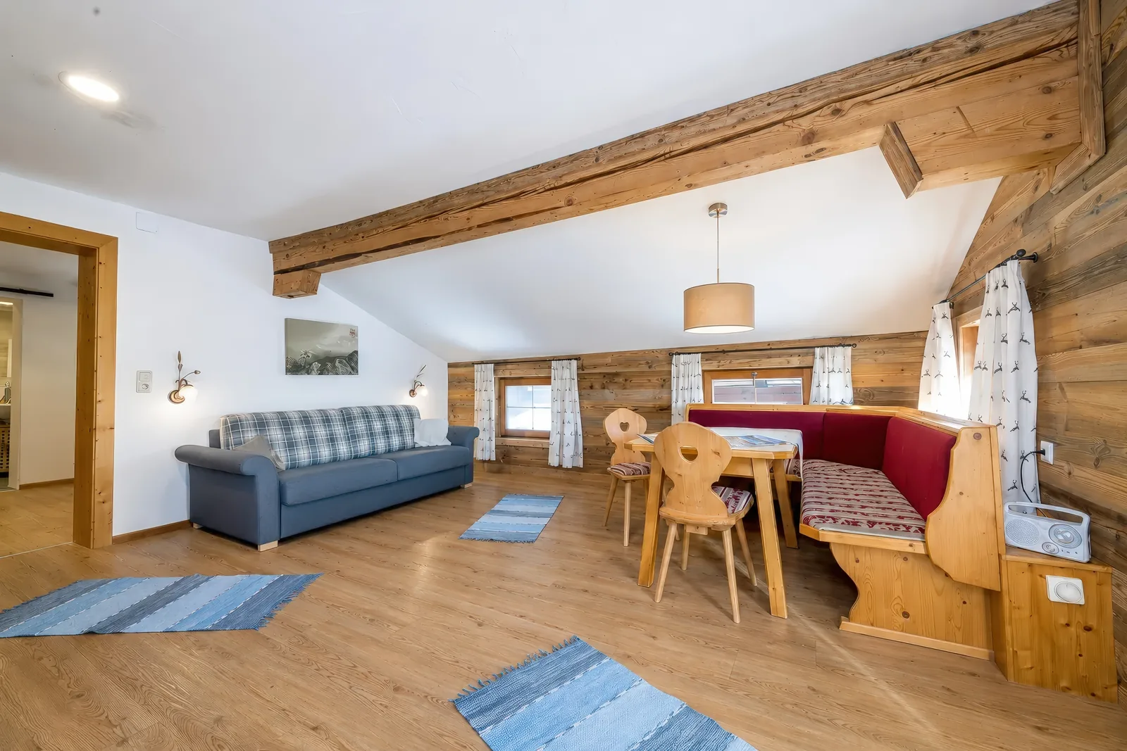 Wohnraum im Alpenblick mit Schlafsofa, Tiroler Eckbank und Esstisch aus Massivholz