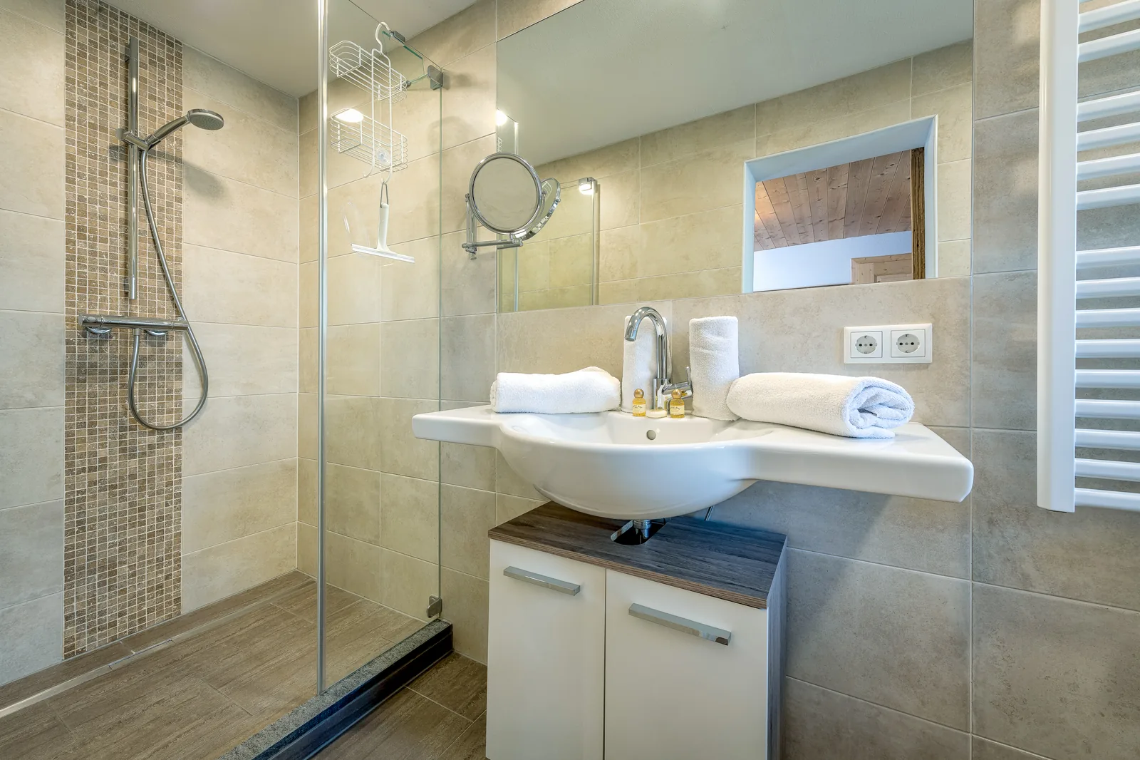 Badezimmer im Kaiserblick mit ebenerdiger Dusche, Waschtisch und Handtuchheizkörper