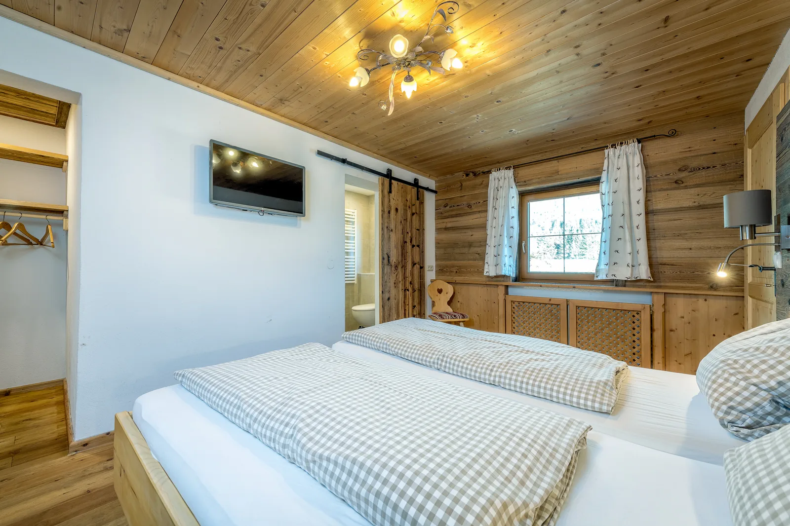 Schlafzimmer der Ferienwohnung Kaiserblick mit Fernseher und Schiebetür zum Bad