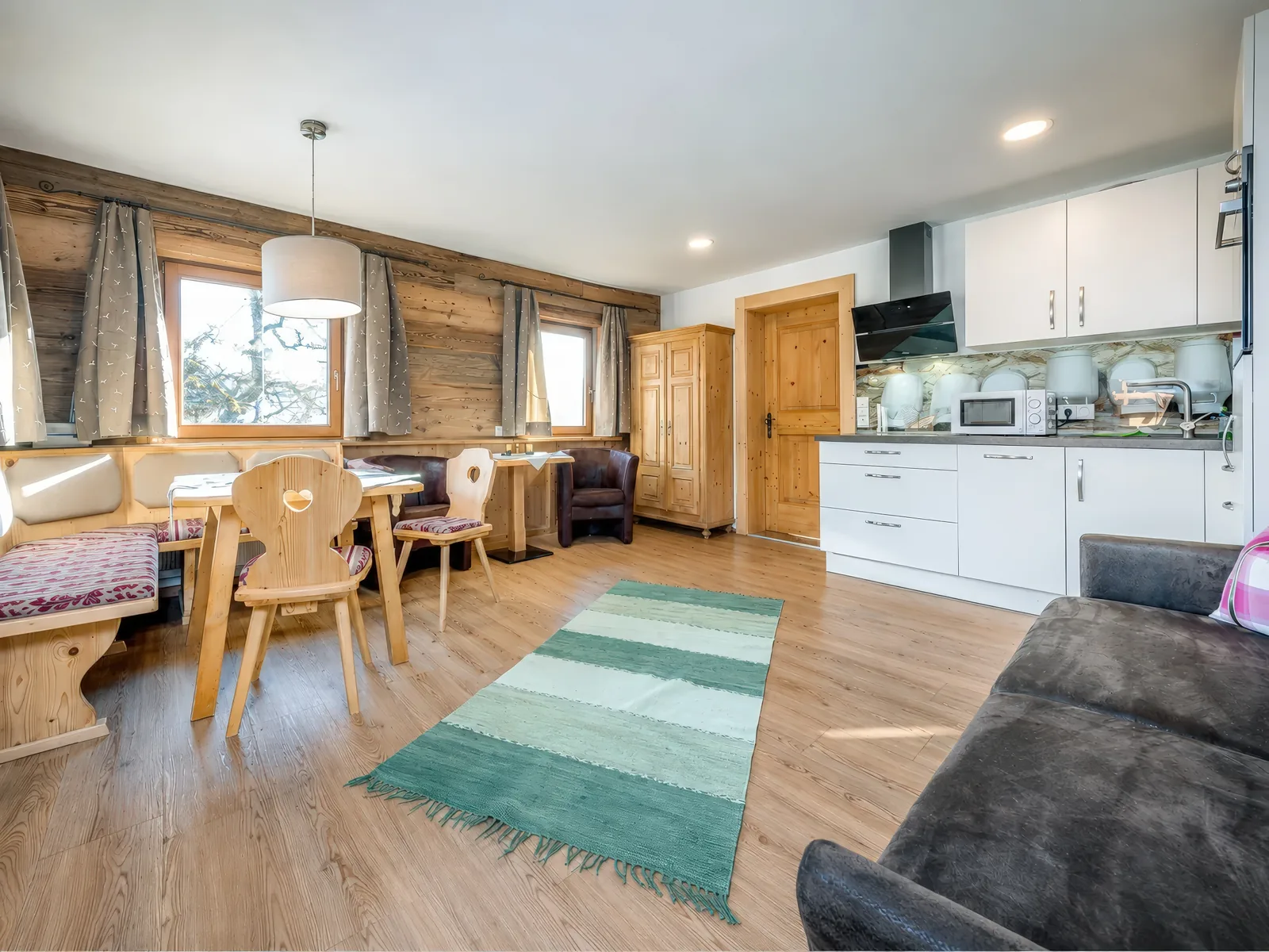 Wohnraum der Ferienwohnung Kaiserblick mit Essplatz, Tiroler Eckbank und offener Küche