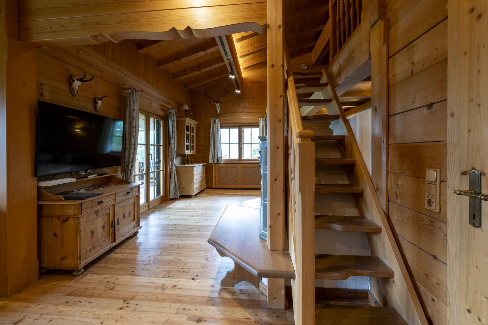 Wohnbereich im Tirolerhaus mit Flat-TV und Treppe zur Galerie