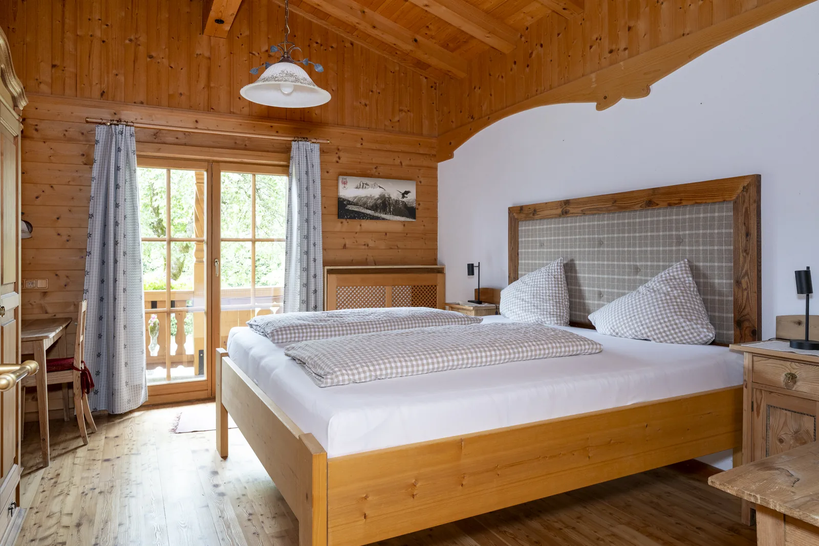 Helles Schlafzimmer mit Holzbett im Tirolerhaus